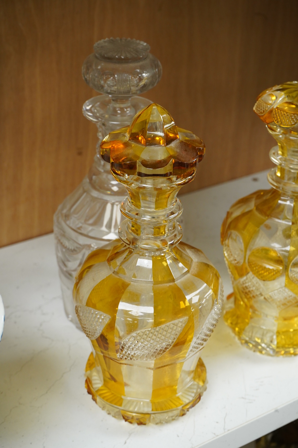 Two late 19th century Bohemian amber flashed decanters and another decanter, tallest 26cm